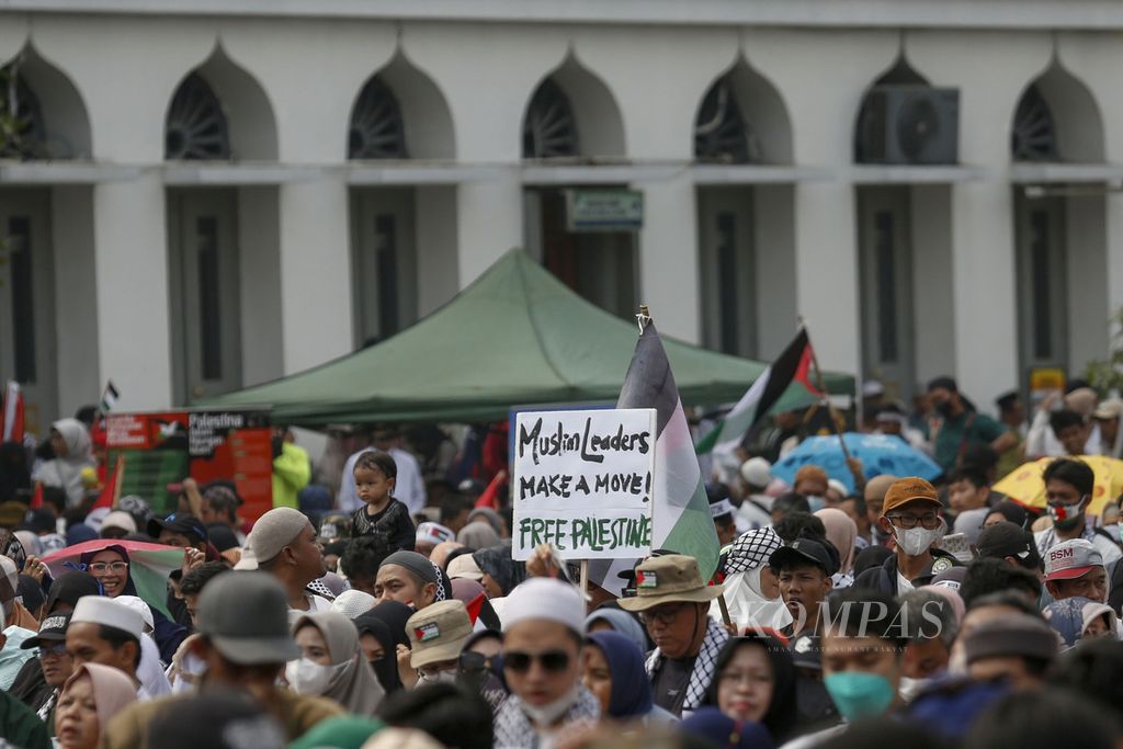 Pengunjuk rasa mengangkat poster berisi pesan dukungan kepada Palestina di lapangan Masjid Agung Al-Azhar, Jakarta, Minggu (15/10/2023). 