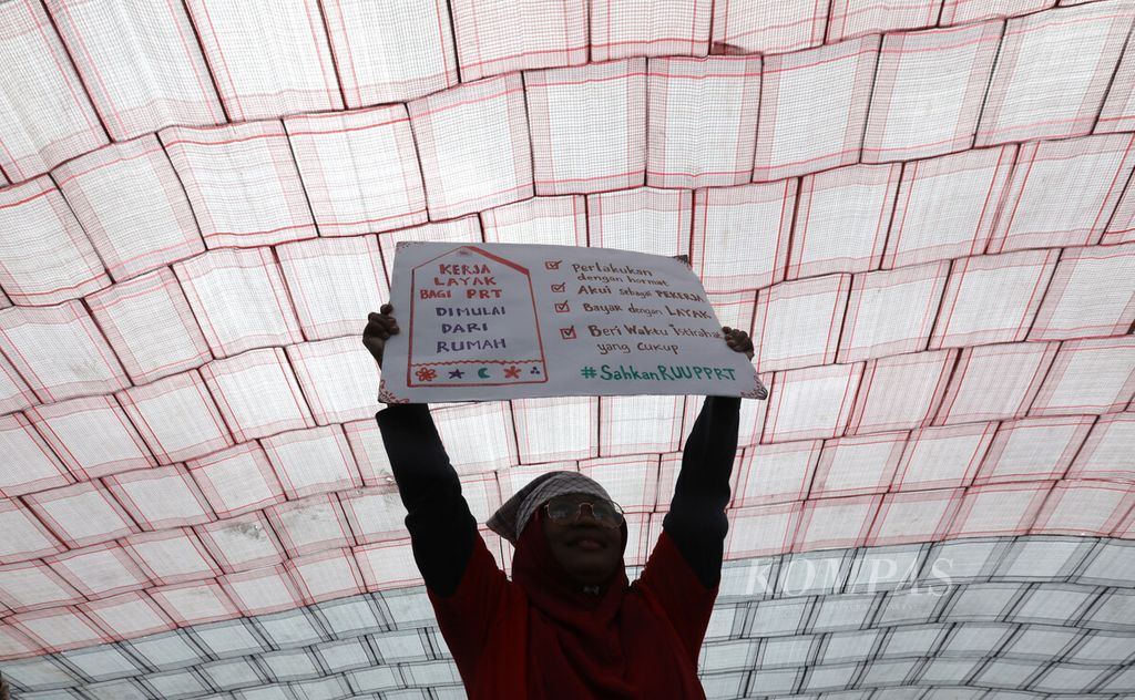 Peserta unjuk rasa membawa poster aspirasi mereka dalam aksi memperingati Hari Pekerja Rumah Tangga di depan Kompleks Parlemen, Jakarta, Rabu (15/2/2023). 