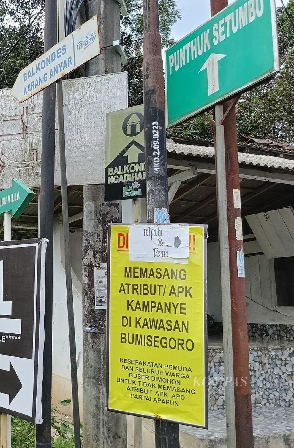 Spanduk<i></i>berisi larangan pemasangan alat peraga kampanye di Dusun Bumisegoro, Desa Borobudur, Kecamatan Borobudur, Kabupaten Magelang, Jawa Tengah, terpasang di antara papan penunjuk arah ke hotel dan sejumlah destinasi wisata di Dusun Bumisegoro, Rabu (17/1/2024).