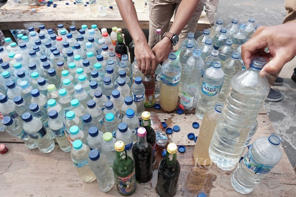 Minuman keras lokal jenis ciu dikemas dalam botol minuman air mineral hasil sitaan aparat Kepolisian Resor Kota Solo di Surakarta, Jawa Tengah, Kamis (19/12/2019).