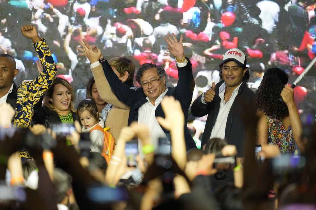 Kandidat presiden Gustavo Petro (tengah) didampingi anaknya, Nicolas Petro (kanan), menyapa para pendukungnya pada masa kampanye pemilihan umum presiden di Bogota, Kolombia, Minggu 29/5/2022). 