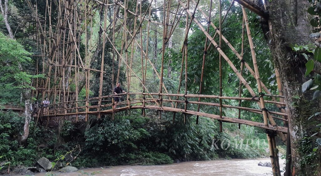 Pengunjung menyeberangi jembatan bambu untuk masuk ke Kampung Cibeo di kawasan Baduy Dalam, Desa Kanekes, Kecamatan Leuwidamar, Kabupaten Lebak, Banten, Sabtu (10/2/2024). 