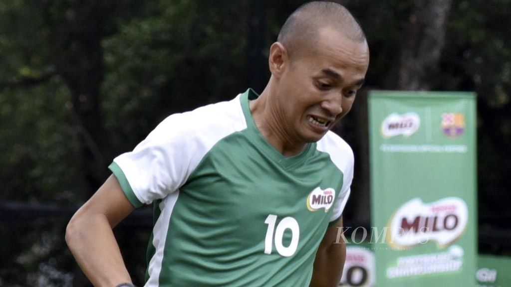 Aksi legenda sepak bola Indonesia, Kurniawan Dwi Yulianto (hijau), dalam laga ekshibisi di sela kejuaraan kelompok usia, MILO Football Championship U-12 2019 di Jakarta, Sabtu (2/3/2019). 