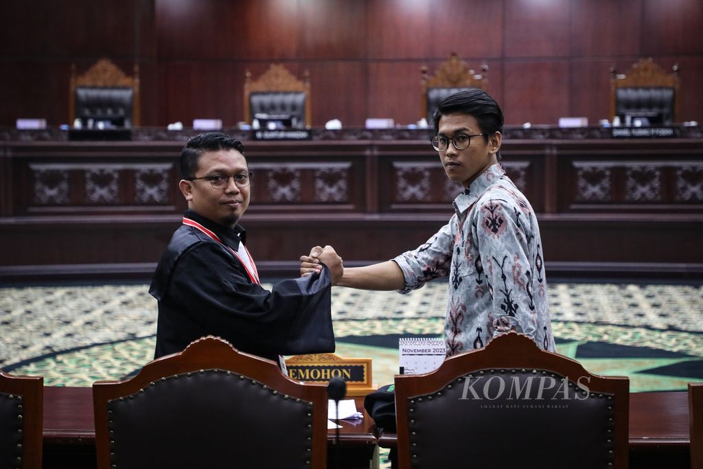 Pemohon gugatan UU Pemilu, Brahma Aryana (kanan), berjabat tangan dengan kuasa hukumnya, Viktor Santoso Tandiasa, sebelum sidang di Gedung Mahkamah Konstitusi, Jakarta, Rabu (8/11/2023). 