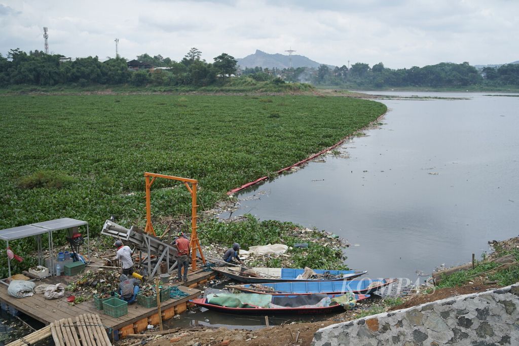Petugas dengan bantuan ban berjalan atau <i>conveyor belt </i>mengangkat sampah dari air Sungai Citarum di Waduk Saguling, Kabupaten Bandung Barat, Jawa Barat, seperti yang terlihat pada Selasa (7/2/2023).