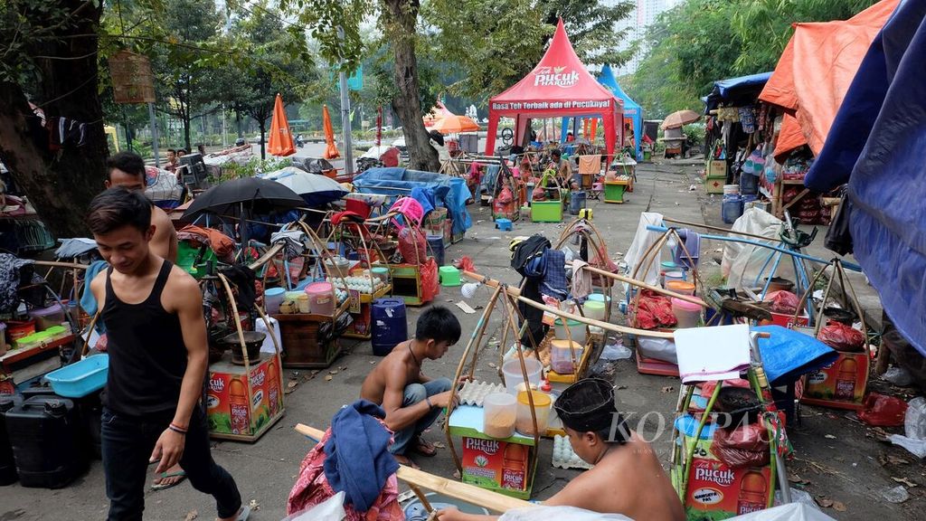 Para penjual kerak telor asal Jawa Barat mencari peruntungan di luar pagar area Jakarta Fair Kemayoran 2018 di Kemayoran, Jakarta Pusat, Rabu (13/6/2018).