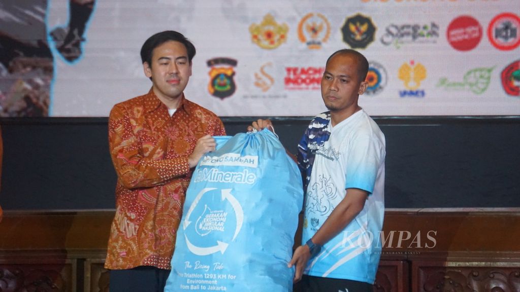 Muryansyah (kanan) memberikan secara simbolis sampah yang dikumpulkan saat melakukan triatlon dari Bali ke Jakarta kepada Director Sustainalibity Mayora Group Ronald Atmadja di Kementerian Lingkungan Hidup dan Kehutanan (KLHK), Jakarta, Selasa (16/8/2022).