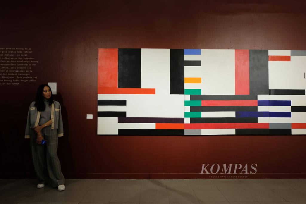 Direktur D Gallerie Esti Nurjadin berdiri di samping lukisan berjudul "Verzon" karya pelukis Nunung WS di Galeri Nasional, Jakarta, Rabu (7/6/2023). Lukisan ini dipajang pada pameran bertajuk "The Spirit Within" di Gedung A Galeri Nasional. Pameran diselenggarakan pada 8-26 Juni 2023 dan menampilkan setidaknya 31 lukisan karya lama dan baru Nunung.