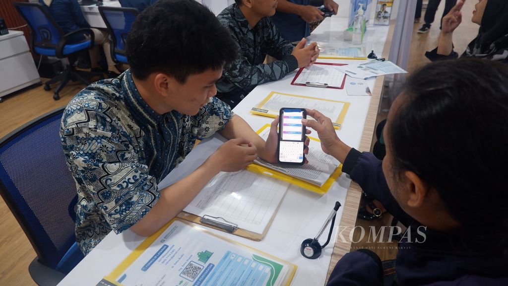 Petugas membantu warga mengaktivasi Mobile JKN di konter layanan BPJS Kesehatan di Mal Pelayanan Publik (MPP) Baiman, Kota Banjarmasin, Kalimantan Selatan, Kamis (25/7/2024). Layanan BPJS Kesehatan di MPP Banjarmasin merupakan bentuk transformasi mutu layanan agar warga mendapatkan pelayanan yang mudah, cepat, dan prima.