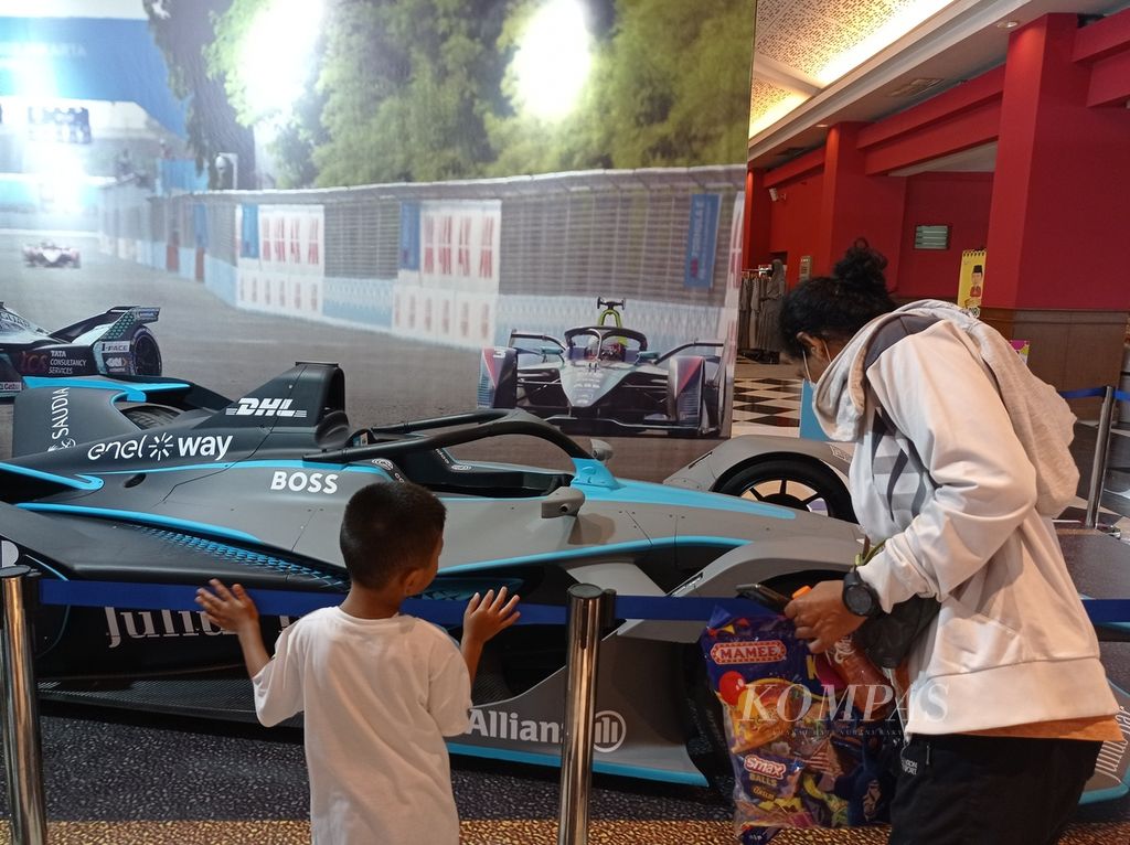 Pengunjung melihat replika mobil balap Formula E di Jakarta Fair Kemayoran atau Pekan Raya Jakarta di Jakarta International Expo, Kemayoran, Jakarta, Kamis (9/6/2022).
