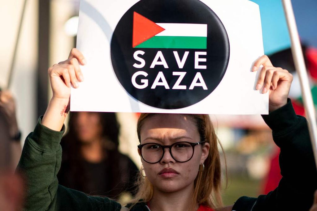 Seorang perempuan mengangkat poster sebagai solidaritas terhadap warga Gaza saat demonstrasi di San Jose, Kosta Rika, 16 Januari 2024. 