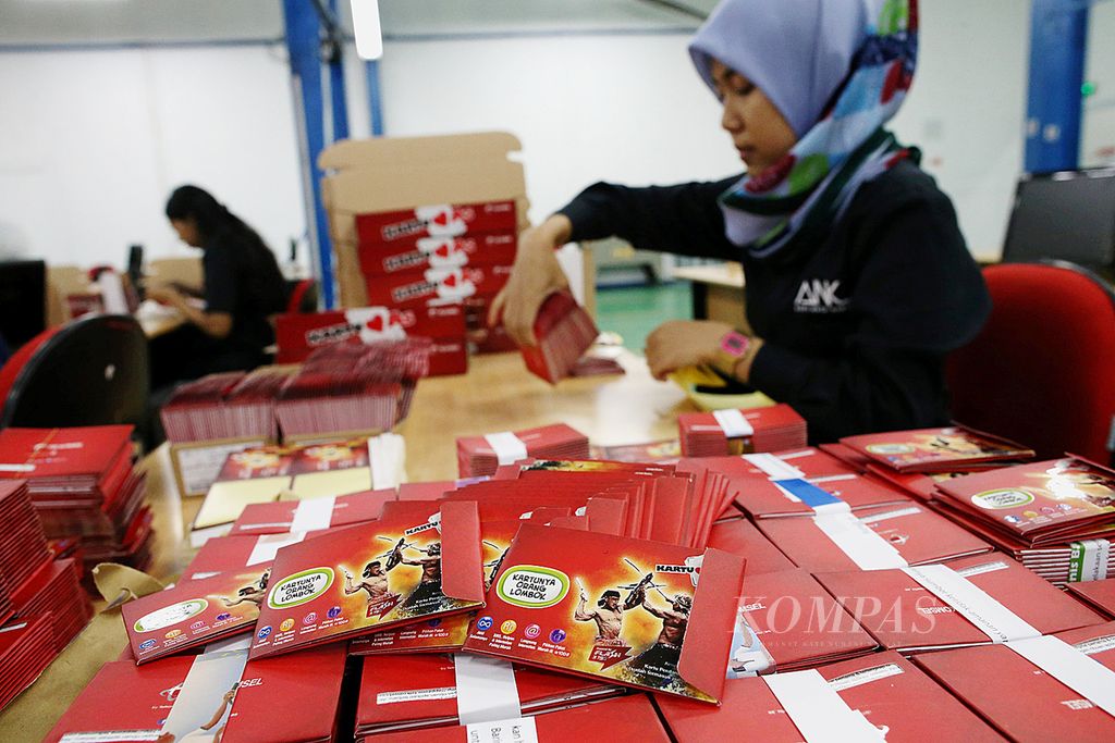 Pegawai Adhi Nata Karya membundel paket kartu perdana Telkomsel di Kawasan Industri Pulogadung, Jakarta, Kamis (21/1/2016). 