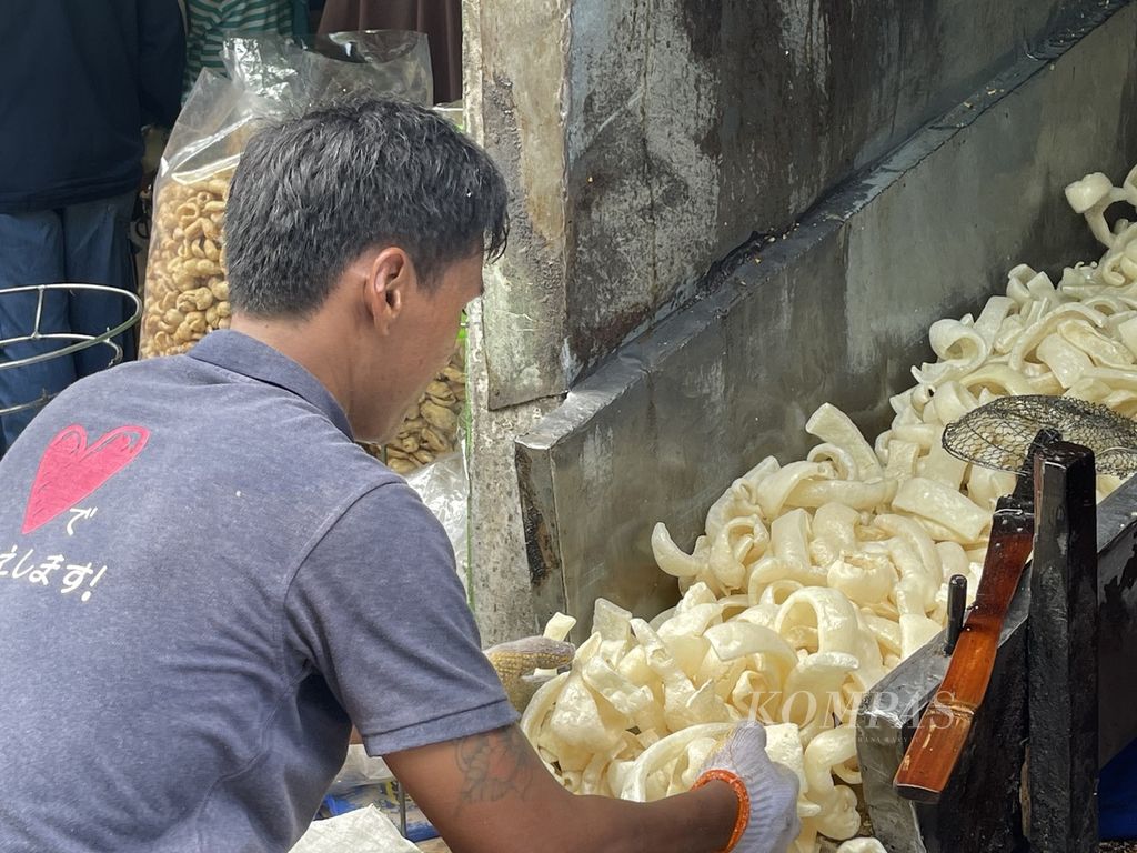 Salah satu pegawai di Toko Lestari di Jalan Pantai Lama Kenjeran, Surabaya, Sabtu (30/4/2022), menggoreng kerupuk khas Kenjeran yang sudah ditunggu pembeli.