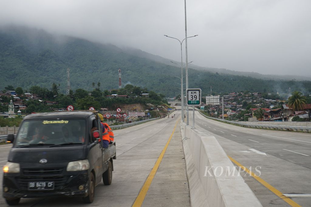 Kendaraan proyek melintas di ujung timur Jalan Tol Manado-Bitung di Bitung, Sulawesi Utara, Jumat (21/1/2022). Mulai dibangun pada 2016, jalan tol sepanjang 39,8 kilometer itu akhirnya rampung dan siap digunakan.