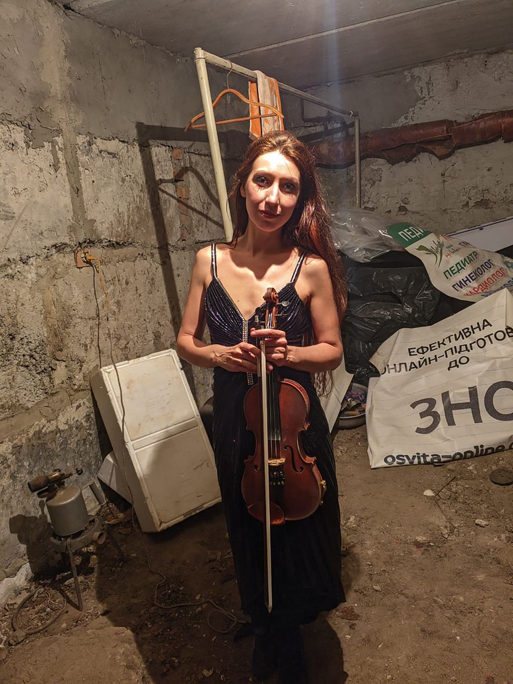 Vera Lytovchenko  memegang biolanya saat berfoto di ruang bawah tanah di apartemennya di Kharkiv, Ukraina, Senin (6/3/2022). Ia menghibur para pengungsi di ruang bawah tanah itu dengan gesekan biolanya. 