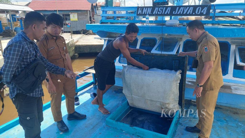 Petugas mengecek muatan ikan laut yang akan dibongkar di Pelabuhan Perikanan Banjarmasin, Kalimantan Selatan, Senin (19/12/2022).