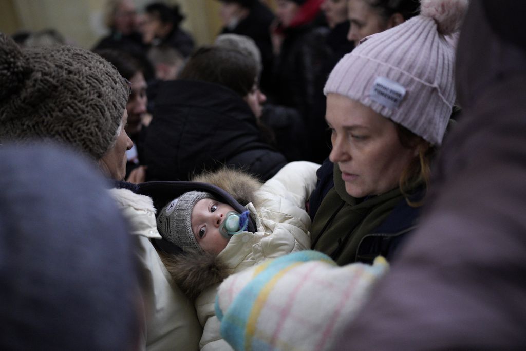 Seorang wanita menggendong bayinya setelah melarikan diri dari konflik dari negara tetangga Ukraina di stasiun kereta api Przemysl di Przemysl, Polandia, Rabu (9/3/2022).