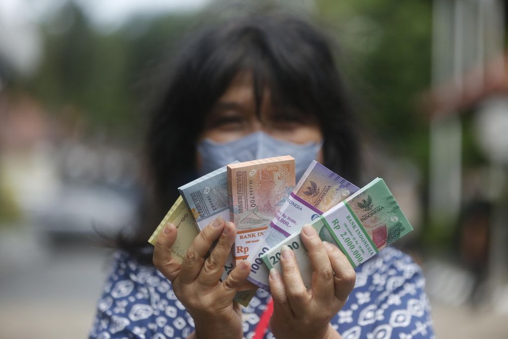 An employee of a company shows bank notes for the year 2022 issue which he successfully exchanged at a bank in Palmerah, Jakarta, Monday (3/4/2023).