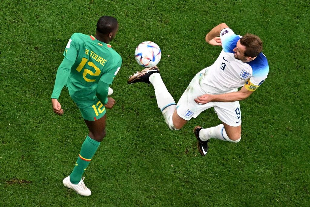 Bek Senegal, Fode Ballo-Toure, berebut bola dengan penyerang Inggris, Harry Kane, dalam pertandingan babak 16 besar Piala Dunia Qatar antara Inggris dan Senegal di Stadion Al Bayt, Al Khor, Senin (5/12/2022) dini hari WIB.