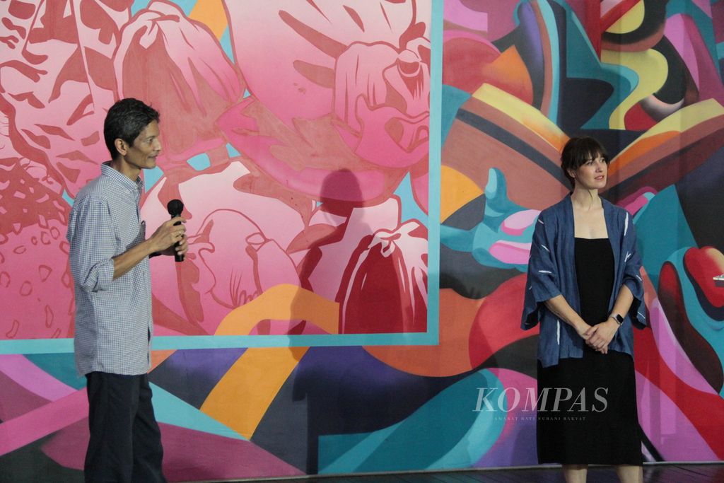 TuTu Erlangga (wearing white) from Indonesia and George Rose (wearing black) from Australia explain their collaborative work, a mural called "Together", during its launch as a commemoration of 75 years of diplomatic relations between Indonesia and Australia at Taman Ismail Marzuki, Jakarta, on Thursday (28/3/2024).