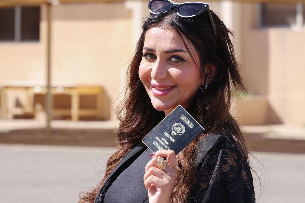 Seorang perempuan Kuwait memperlihatkan paspornya saat tiba untuk menggunakan hak suaranya pada pemilu legislatif di sebuah TPS di Kuwait City, Kuwait, 4 April 2024. 