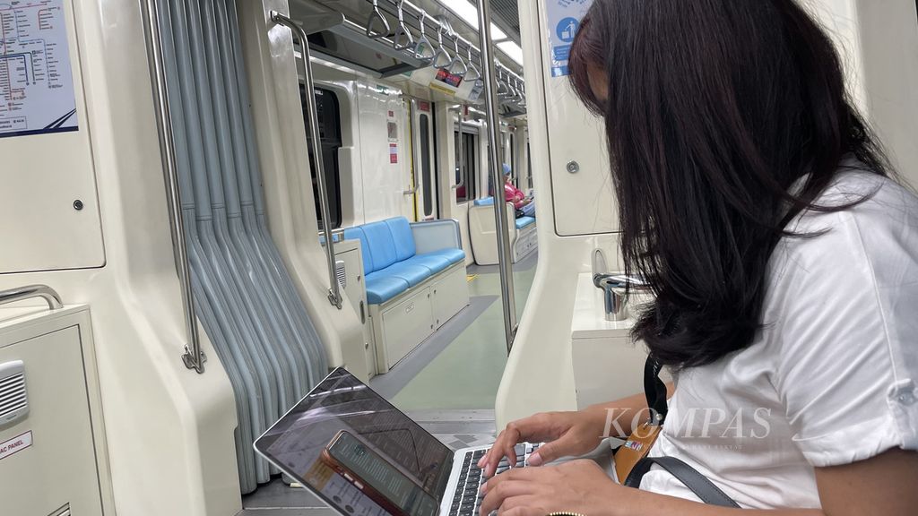 Seorang pekerja muda terpantau membuka laptop di dalam gerbong LRT Jabodebek sekitar pukul 22.00, Minggu (11/2/2024), untuk mencicil pekerjaan dari kantornya. Pekerjaan menjadi salah satu isu bagi pekerja yang tergolong pemilih muda (usia 17-40 tahun) kelas menengah.