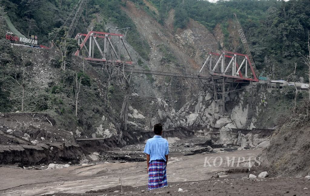 Warga mengamati Jembatan Gantung Gladak Perak yang rusak akibat erupsi Semeru, di Kecamatan Candipuro, Kabupaten Lumajang, Jawa Timur, Rabu (7/12/2022).
