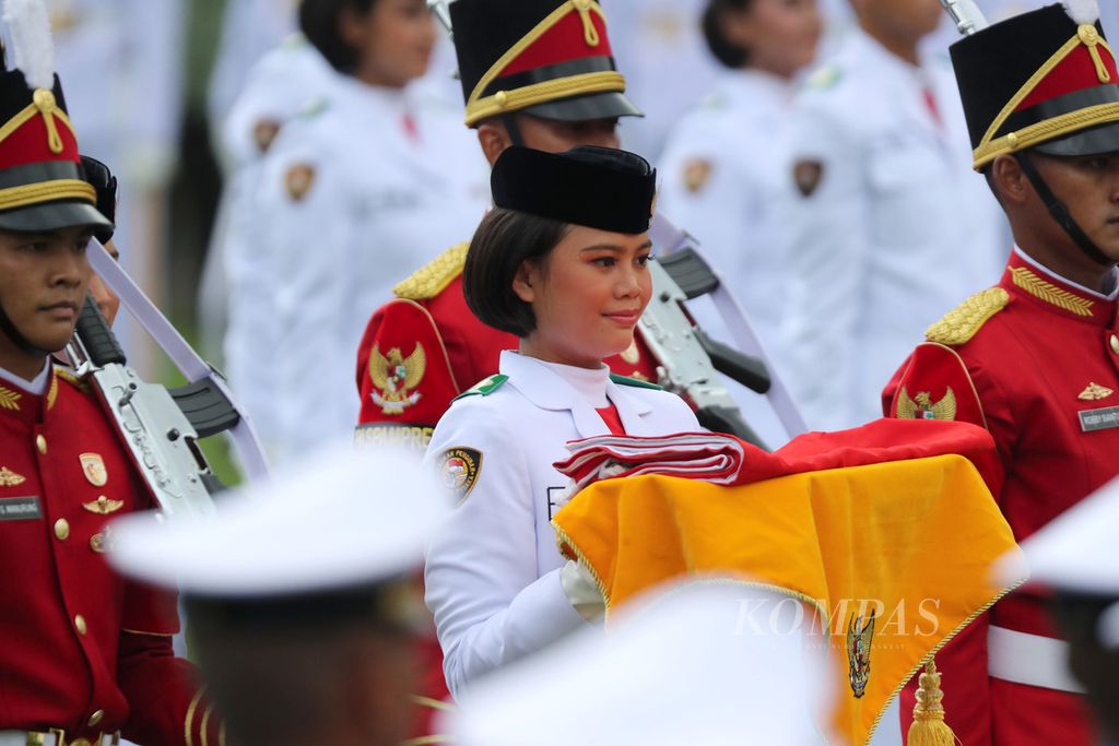 I Dewa Ayu Firsty Meita Dewanggi membawa bendera Merah Putih untuk dikibarkan dalam Upacara Peringatan Detik-detik Proklamasi Kemerdekaan RI di Istana Merdeka, Jakarta, Rabu (17/8/2022). 