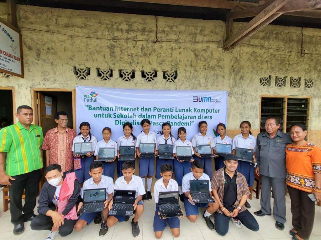 Siswa SMP Kristen Cahaya Kasih Sumba Barat Daya memegang laptop bantuan PLN NTT, bersama para guru di sekolah itu, di Tambolaka, Senin (14/6/2022).