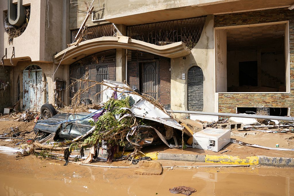 Gambar yang disediakan oleh kantor perdana menteri sementara Libya yang berbasis di Benghazi pada 11 September 2023 menunjukkan pemandangan kendaraan yang hancur di dekat bangunan yang rusak di Kota Derna, sekitar 290 kilometer timur Benghazi, setelah banjir bandang melanda. 