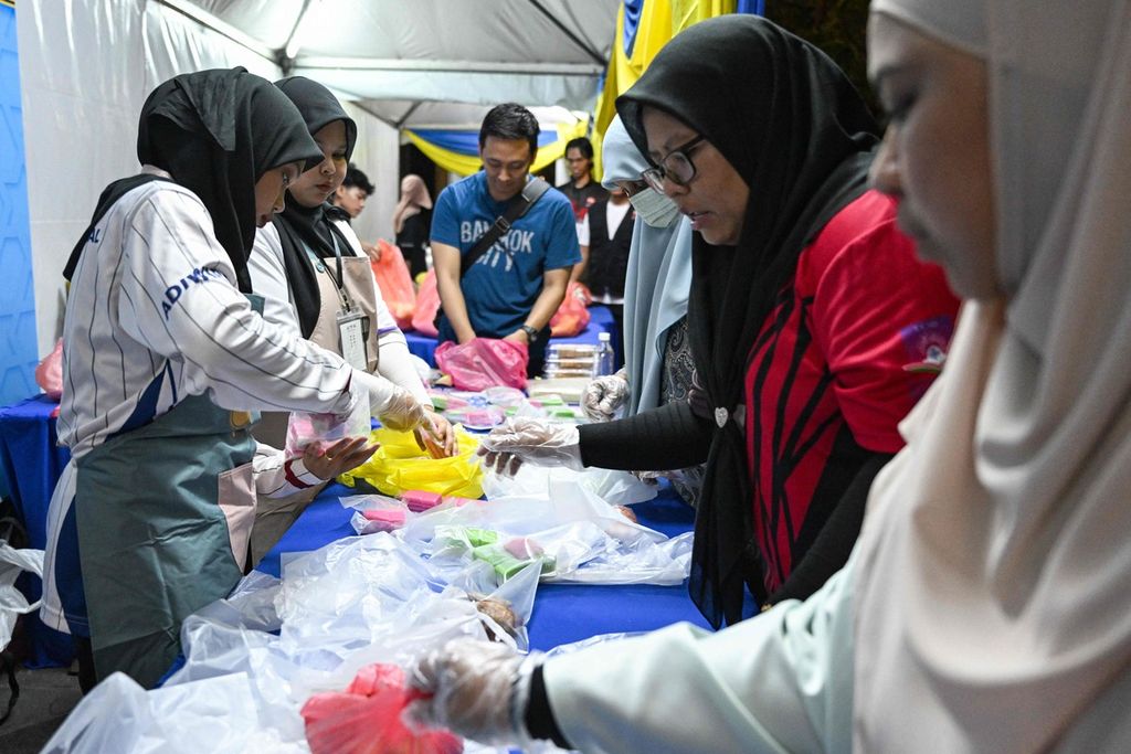  Sukarelawan dari LSM GEMA Malaysia menimbang makanan yang tidak terjual, yang dikumpulkan dari pasar, sebelum dibagikan kepada orang-orang yang membutuhkan di lingkungan Kampung Baru, Kuala Lumpur, Malaysia, selama bulan suci Ramadhan, 18 Maret 2024. 