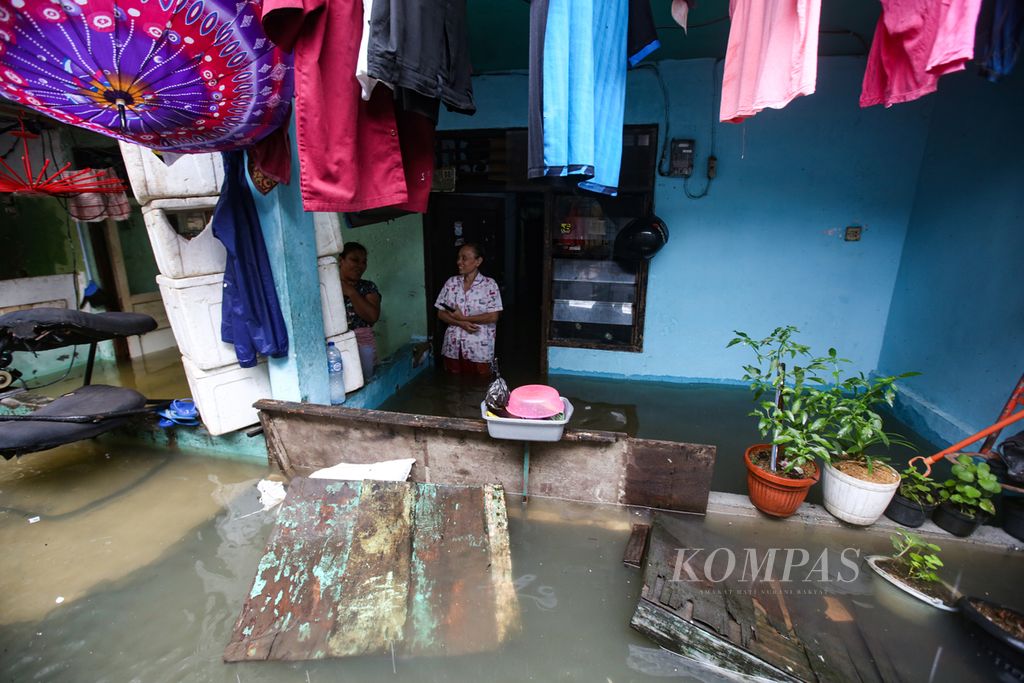 Warga bertahan di dalam rumah kontrakan yang terendam banjir di Kelurahan Kapuk, Kecamatan Cengkareng, Jakarta Barat, Jumat (22/3/2024). 
