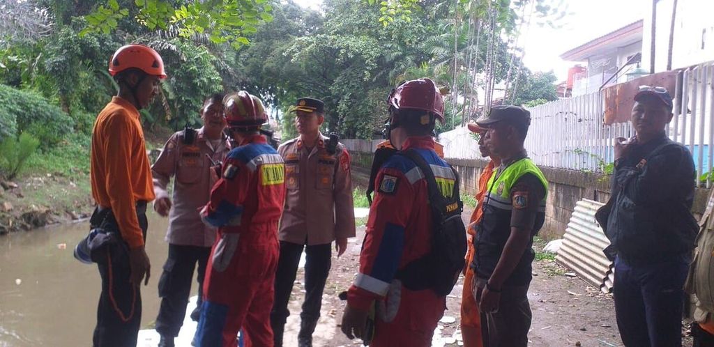 Petugas berkoordinasi untuk mencari dua korban yang diduga terseret arus Kali Mampang, Jakarta Selatan, Sabtu (2/3/2024). Keduanya hilang setelah berenang di kali ketika hujan turun. 