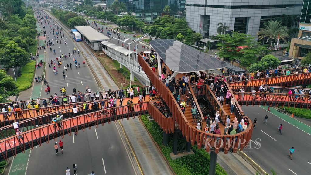 Warga memadati jembatan penyeberangan orang Pinisi memanfaatkan hari bebas kendaraan bermotor (HBKB) di Jalan Sudirman, Jakarta Selatan, Minggu (22/5/2022). 
