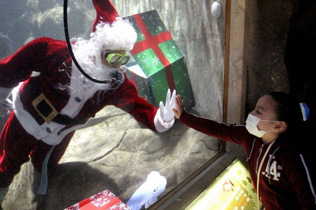  Penyelam yang berdandan sebagai Sinterklas menyapa pengunjung dari dalam akuarium Kebun Binatang Guadalajara menjelang libur Natal di Guadalajara, Meksiko, Sabtu (18/12/2021).
