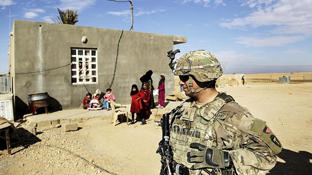 Tentara Amerika Serikat berbicara dengan keluarga di perdesaan Anbar saat patroli pengintaian dekat pos terdepan pasukan koalisi di Irak barat. Foto itu diambil pada 27 Januari 2018. 