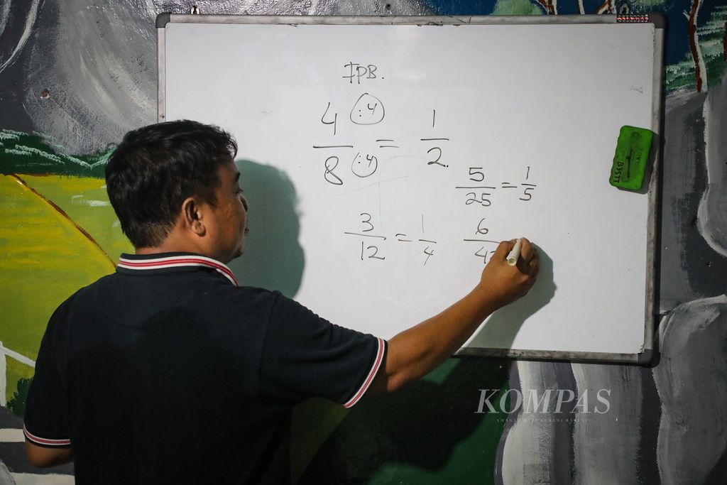 Abi, mentor bimbingan belajar, menjelaskan materi matematika kepada para siswa di Sekretariat RW 006, Kebon Melati, Tanah Abang, Jakarta Pusat, Jumat (22/9/2023). 