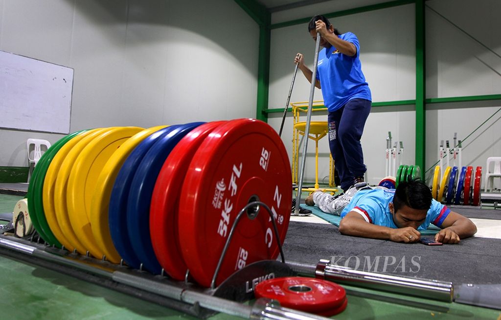 Lifter Deni (67 kg) melakukan <i>stretching</i> sebelum berlatih di arena angkat besi Rizal Memorial Stadium di Manila, Filipina, pada November 2019,