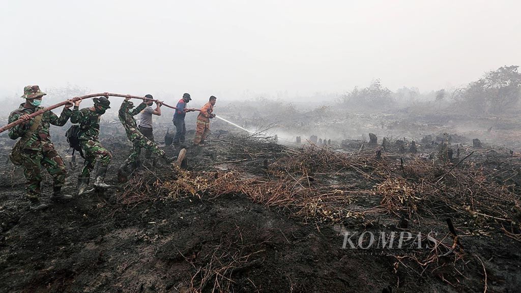 Petugas gabungan berusaha memadamkan kebakaran lahan gambut di Desa Rimbo Panjang, Kecamatan Tambang, Kabupaten Kampar, Riau, Sabtu (5/9). 