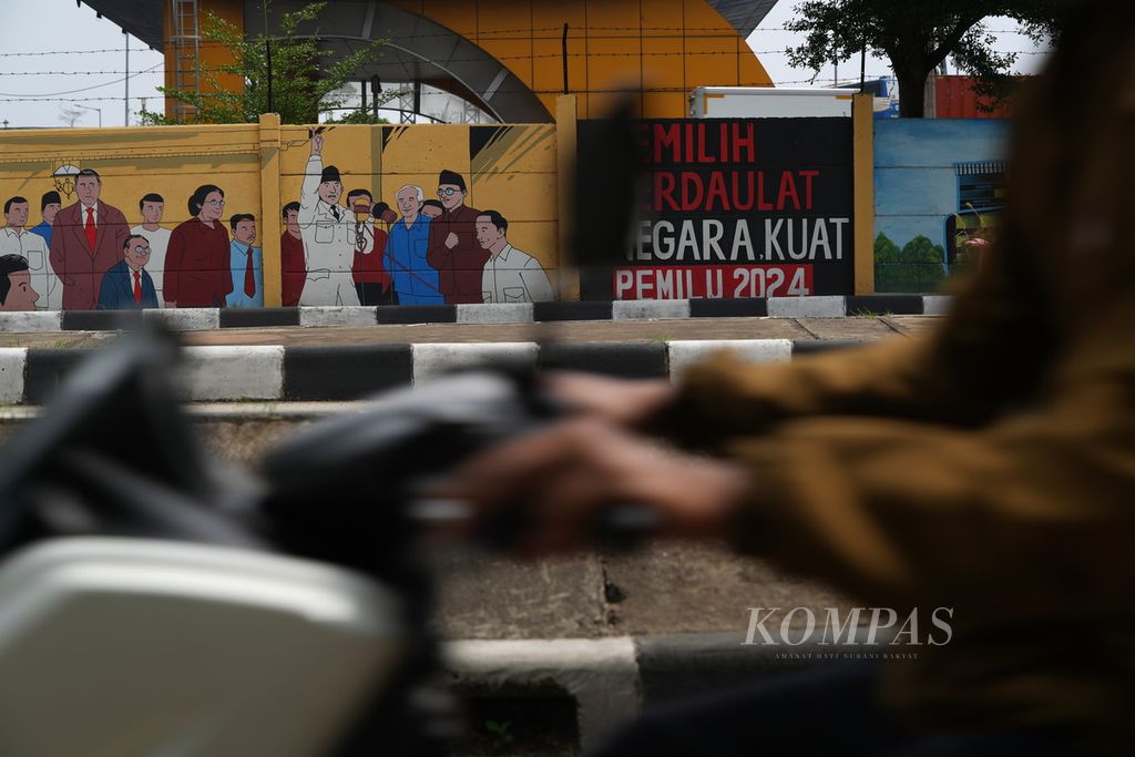 Pengendara sepeda motor melintasi mural berisi ajakan untuk memilih dalam Pemilu 2024 di Jalan Cakung-Cilincing Barat, Jakarta Timur, Jumat (29/12/2023). 