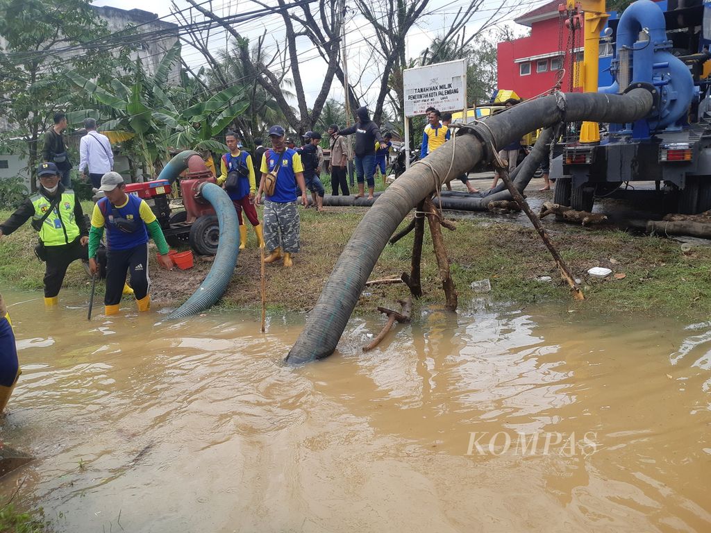 Petugas memasang pompa di salah satu titik banjir di Jalan R Soekamto, Palembang, Sumatera Selatan, Kamis (6/10/2022). Pasang Sungai Musi dan cuaca ekstrem membuat sejumlah titik di Kota Palembang terendam. Kondisi itu  menghambat aktivitas warga.