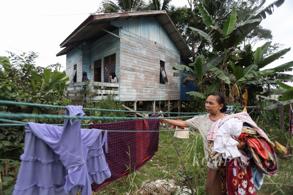 Dalisah (45) mengangkat jemuran di halaman rumahnya di Kelurahan Sepaku, Kecamatan Sepaku, Kabupaten Penajam Paser Utara, Kalimantan Timur, Minggu (31/12/2023).