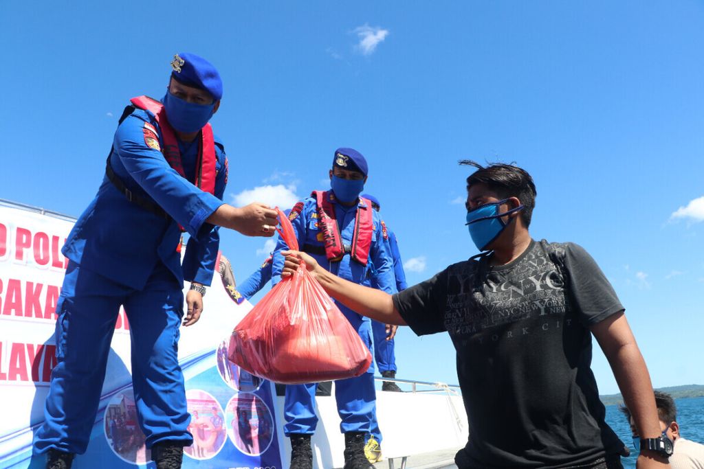 Polda NTT menyerahkan bantuan bahan pokok kepada nelayan, berlangsung di tengah laut (18/42020). Selain bahan pokok juga laat pelampung dan masker bagi 100 nelayan di Kupang dan sekitarnya.