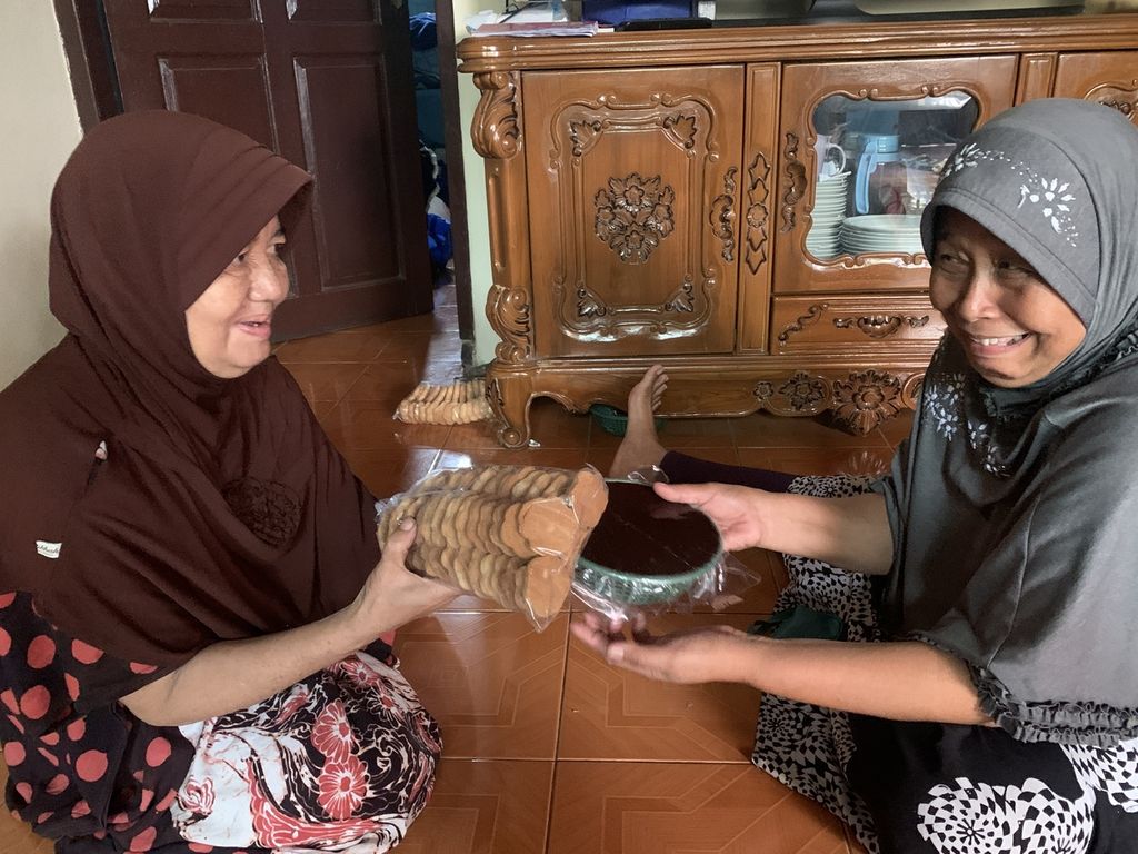 Mpok Habiba (kiri) bertukar kuliner khas Lebaran dengan kerabatnya di rumahnya di Kampung Kuliner Dodol Betawi, Pasar Minggu, Jakarta Selatan, Rabu (19/4/2023).