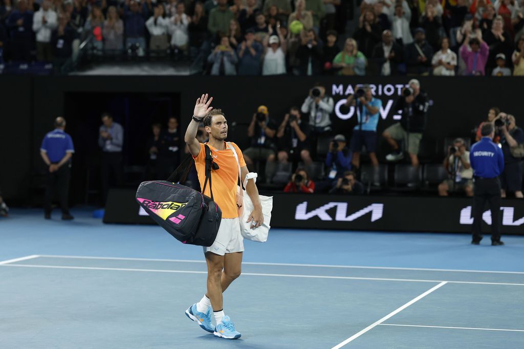 Juara bertahan Rafael Nadal melambaikan tangan tanda berpamitan pada penonton sebelum meninggalkan Rod Laver Arena menyusul kekalahannya dari Mackenzie McDonald (Amerika Serikat) pada laga babak kedua turnamen Grand Slam Australia Terbuka di Melbourne Park, Melbourne, Australia, Rabu (18/1/2023). 