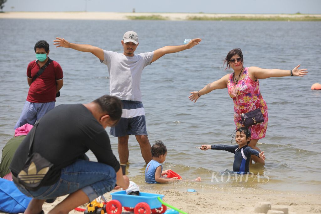 Pengunjung berfoto di pantai di Beach Pool Taman Impian Jaya Ancol, Jakarta Utara, beberapa waktu lalu. Liburan panjang dimanfaatkan warga untuk berwisata ke tempat wisata pantai tersebut.