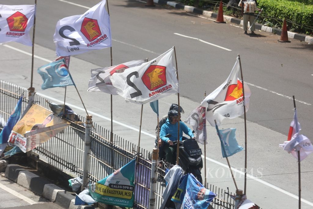 Alat peraga kampanye terpasang di pagar pembatas di sepanjang Jalan Arteri Pondok Indah, Jakarta Selatan, Sabtu (20/1/2024). 