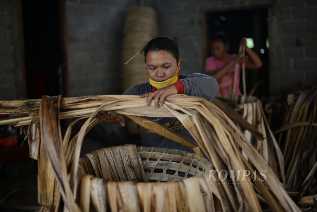 Ibu rumah tangga merakit keranjang tempat tembakau di Dusun Sidosari, Desa Jelok, Cepogo, Boyolali, Jawa Tengah, Senin (3/8/2020). Dalam sehari mereka dapat mengerjakan sekitar sepuluh pasang keranjang dengan upah Rp 15.000 untuk setiap pasang keranjang yang mereka buat. Keranjang berbahan kulit batang pohon pisang dan bambu tersebut dijual dengan harga Rp 160.000 - Rp 200.000 per pasang, tergantung bobotnya. Melalui pekerjaan itu para ibu rumah tangga dapat membantu meringankan pemenuhan kebutuhan sehari-hari keluarga mereka.