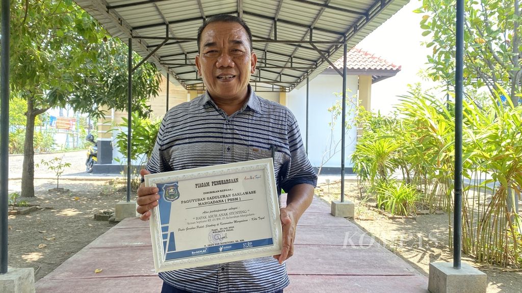 Joko Margo Purnomo (54) menunjukkan piagam penghargaan dari Wali Kota Tegal Dedy Yon Supriyono di Kecamatan Margadana, Kota Tegal, Jawa Tengah, Selasa (3/10/2023). 