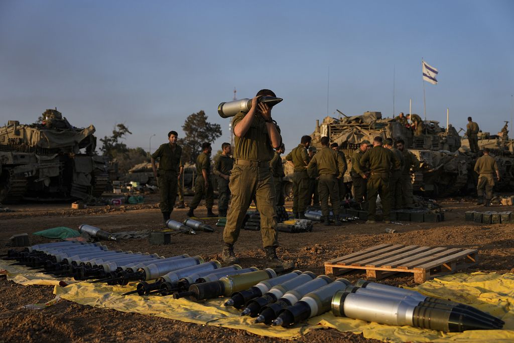 Tentara Israel mengangkut peluru ke tank di area persiapan di Israel selatan dekat perbatasan dengan Gaza, Minggu (31/12/2023). 